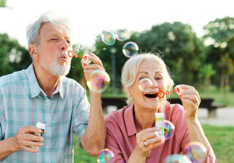 Senior adults joyfully blowing bubbles